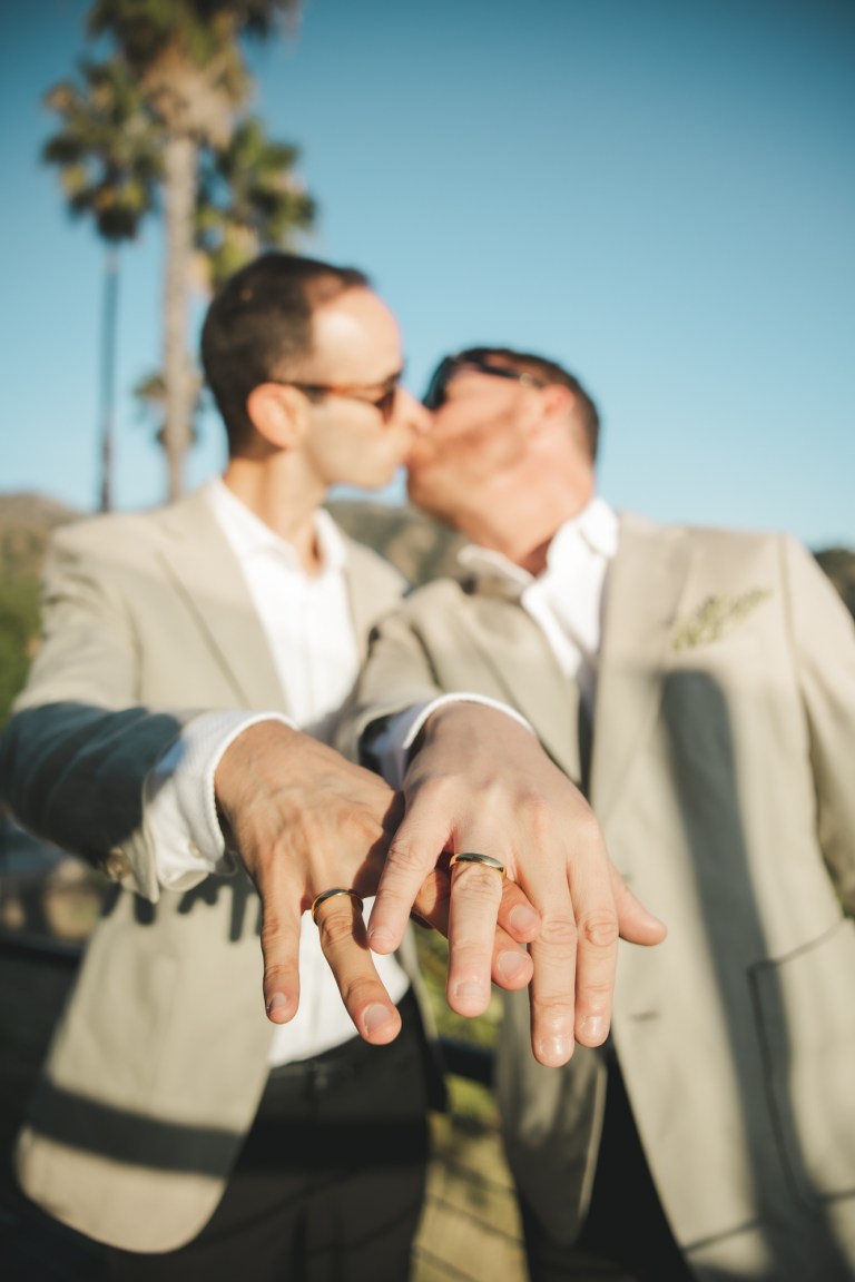 LGBTQ couple showing wedding rings after engagement