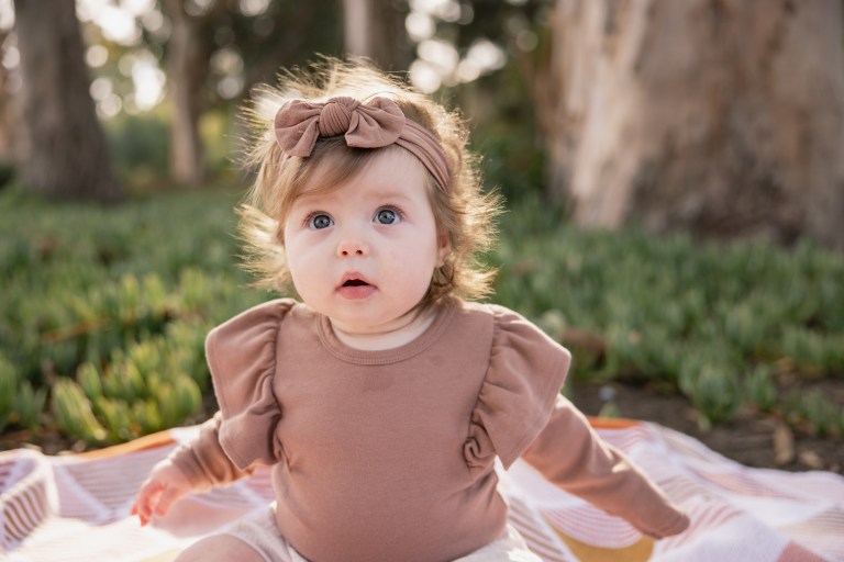 Baby in neutral outfit looking at camera