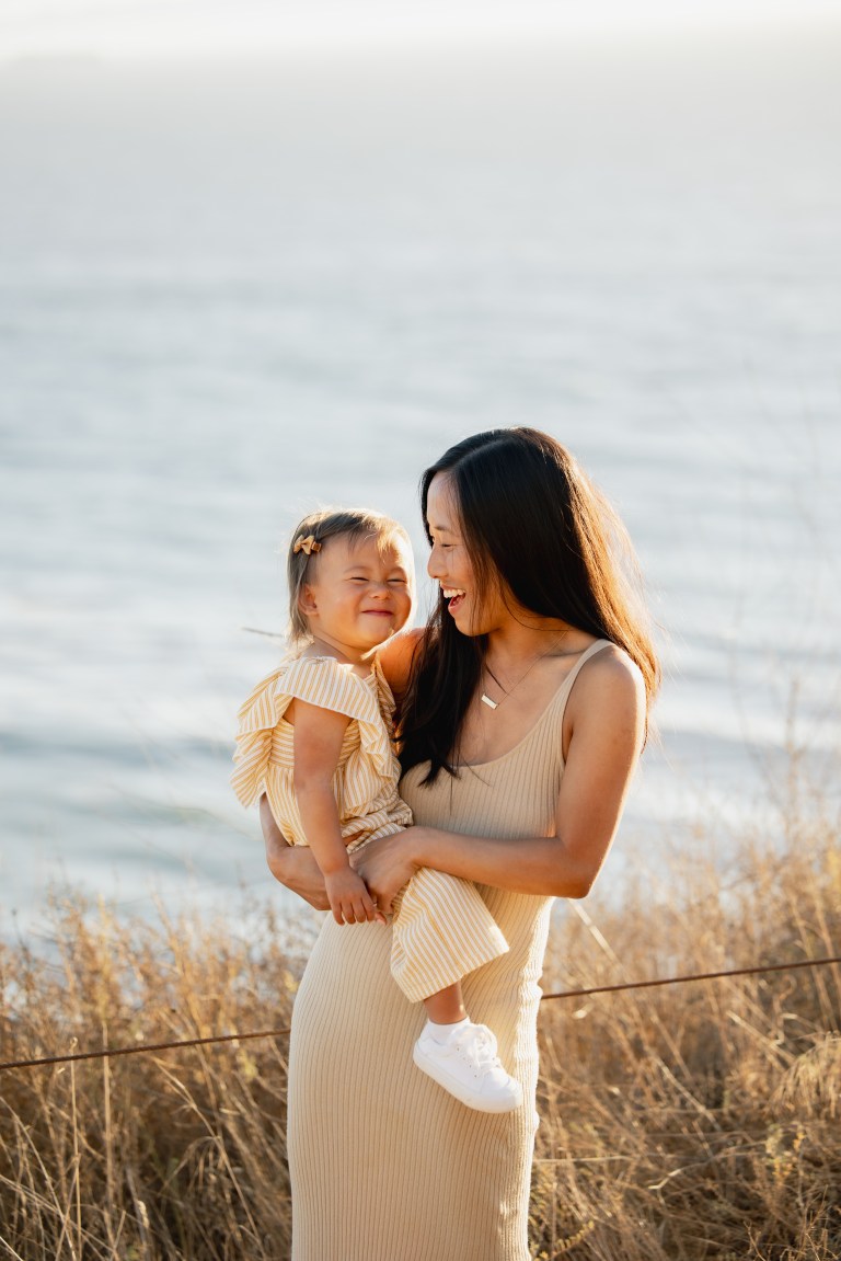 Mother holding baby at sunset on Los Angeles beach